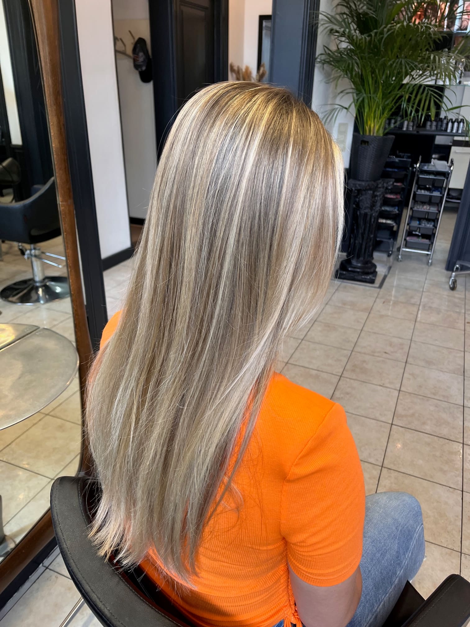 Steil geföhnd blond haar met lichte highlights tot over de rug.