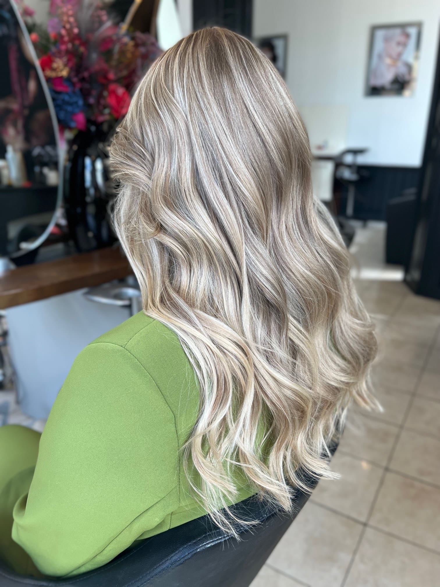 Blond haar met koele highlights in brede golven over de schouder.